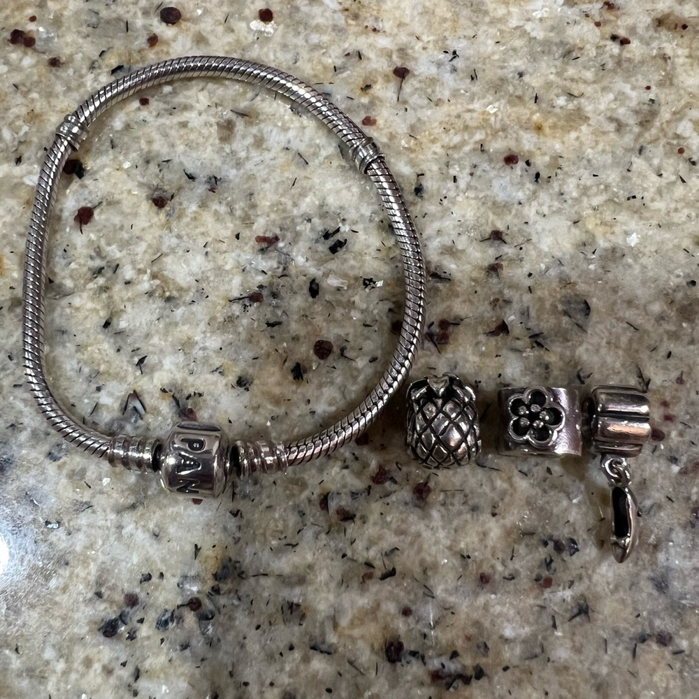 Pandora bracelet with 3 charms. Flower, shoe and pineapple charms.